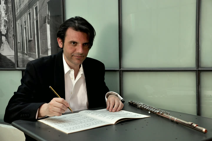 Paolo Emmanuel Ferrigato al tavolo, con lo spartito e il flauto accanto